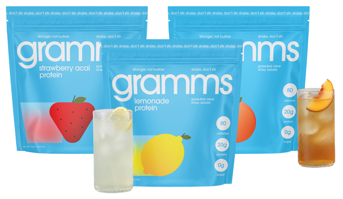 Three bags of gramms protein with glasses of lemonade, strawberry and peach iced tea